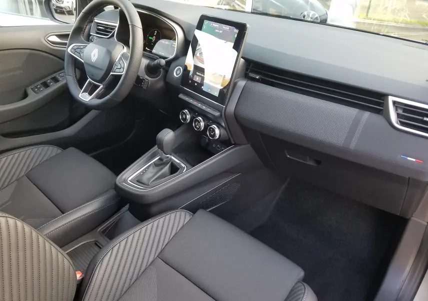 Intérieur avant droit de la Renault Clio V 1.6E-TECH Hybride avec écran tactile vertical et sellerie noire rayée.