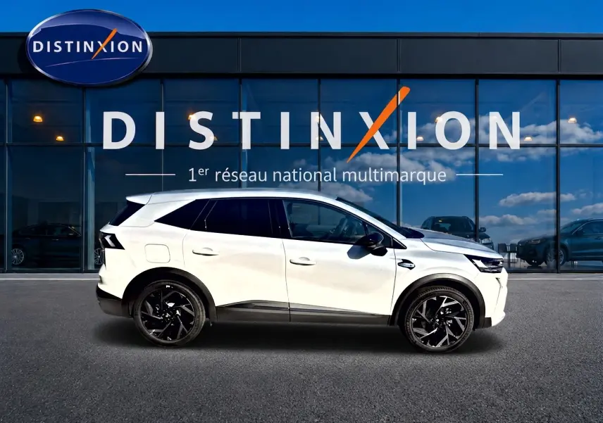 Profil droit du Renault Symbioz blanc nacré 2026 avec jantes noires, devant une vitrine Distinxion.