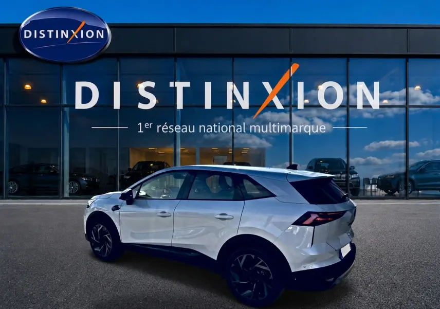 Renault Symbioz blanc nacré en vue profil côté gauche, avec jantes alu noires et feux arrière LED distinctifs.