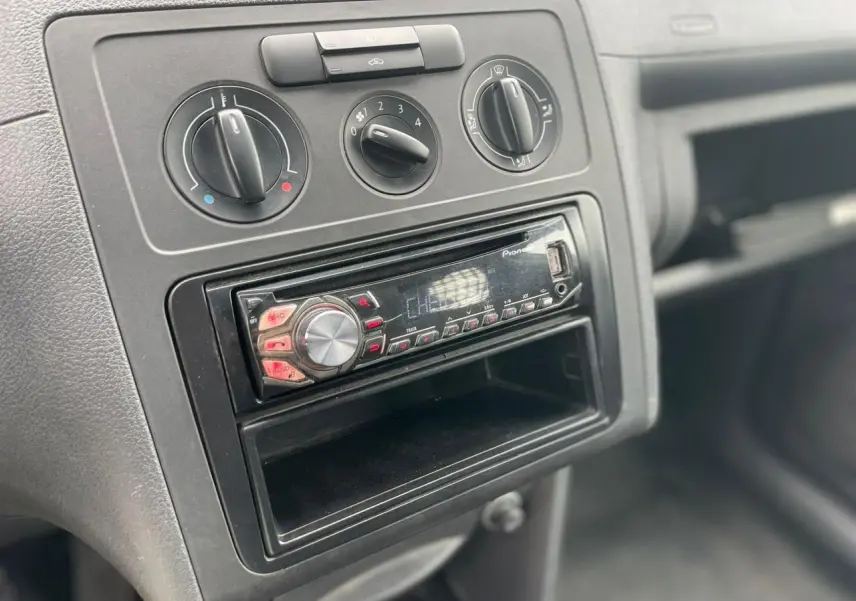 Gros plan sur la console centrale du Volkswagen Caddy 2014 avec commandes de climatisation et radio Pioneer.