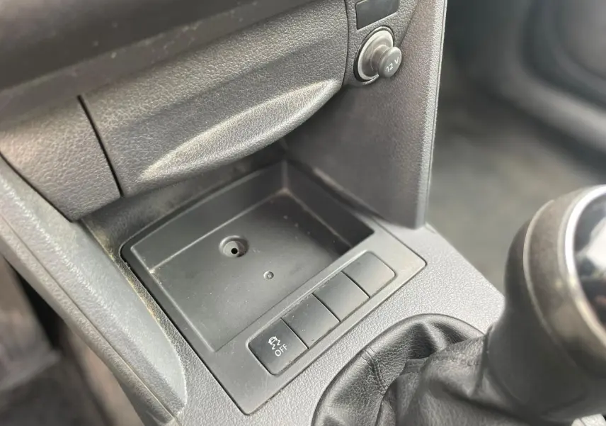 Gros plan sur la console centrale noire du Volkswagen Caddy blanc avec levier de vitesse manuel et bouton de contrôle ESP off.