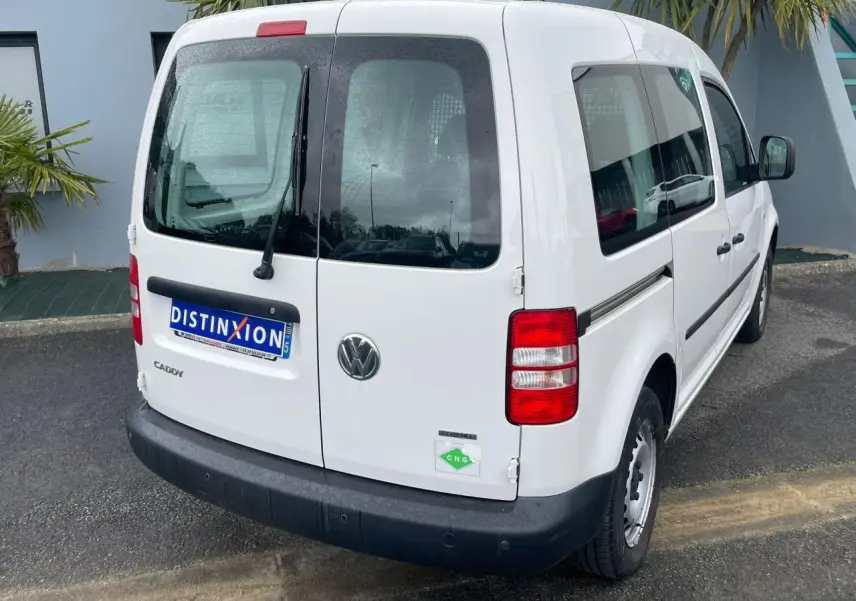 Vue 3/4 arrière droite d'un Volkswagen Caddy blanc Candy Van 2.0i Ecofuel avec galerie de toit et badge CNG.