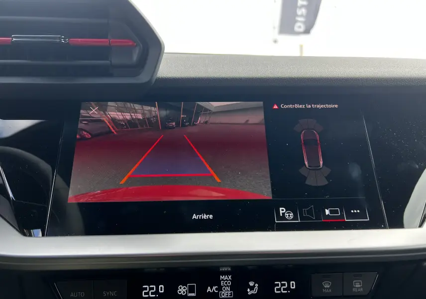 Vue de l'écran multimédia de l'Audi RS3 Sportback rouge 2022 affichant la caméra de recul et l'aide au stationnement.