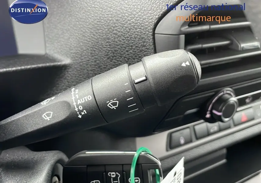 Gros plan sur la commande d'essuie-glace à gauche du volant dans l'habitacle du Peugeot Expert Fourgon blanc 2025.