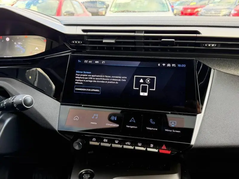 Vue rapprochée du tableau de bord de la Peugeot 308 2024, avec écran tactile central et commandes tactiles sous l'écran.