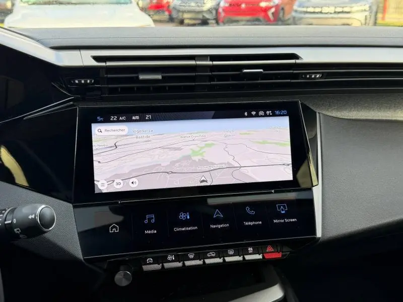 Vue intérieure centrée sur l’écran tactile de navigation de la Peugeot 308 2024 avec tableau de bord noir.