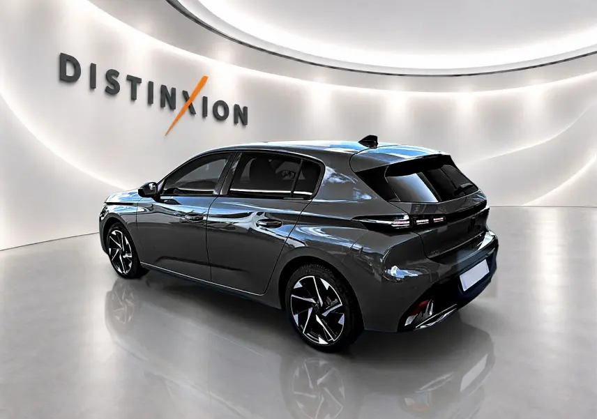 Peugeot 308 gris selenium en 3/4 arrière droit, avec jantes alu noires et feux arrière LED distinctifs.