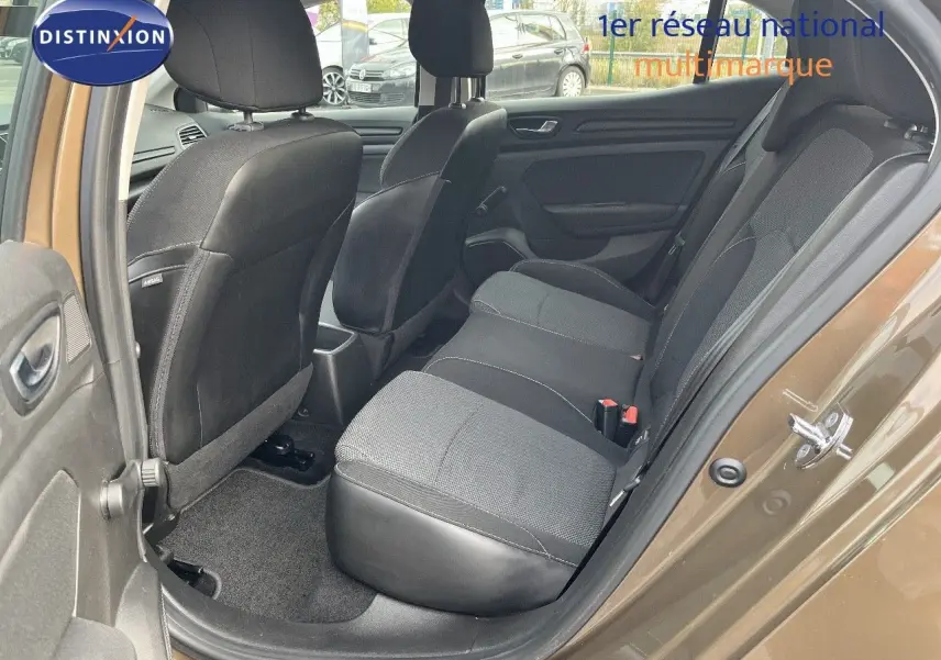 Vue côté gauche arrière de l'habitacle d'une Renault Mégane IV brun cappuccino, sièges tissu noirs et gris visibles.