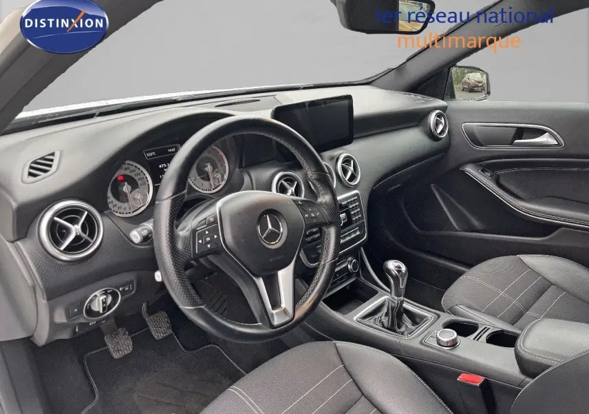 Vue intérieure côté conducteur d'une Mercedes Classe A 180 Sensation 2013 avec volant cuir et boîte manuelle.