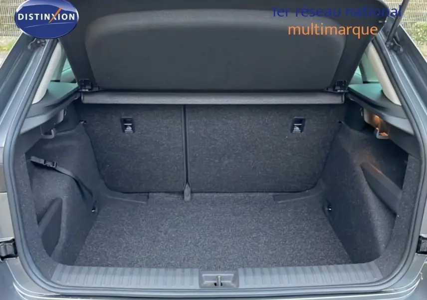 Coffre ouvert vu de l'arrière d'un Skoda Kamiq gris graphite métal, montrant l'espace de chargement vide.