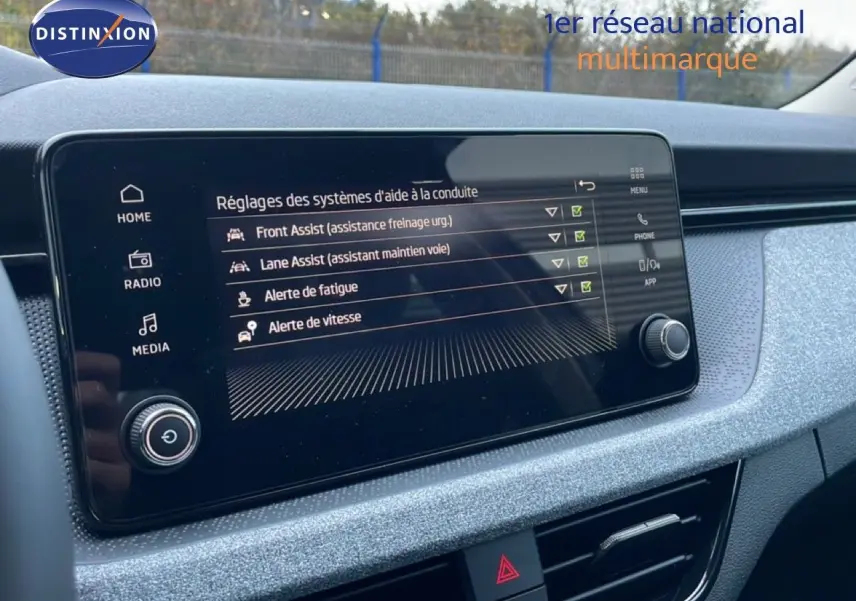 Vue rapprochée de l’écran tactile intérieur du Skoda Kamiq 2025 gris graphite, affichant les aides à la conduite.