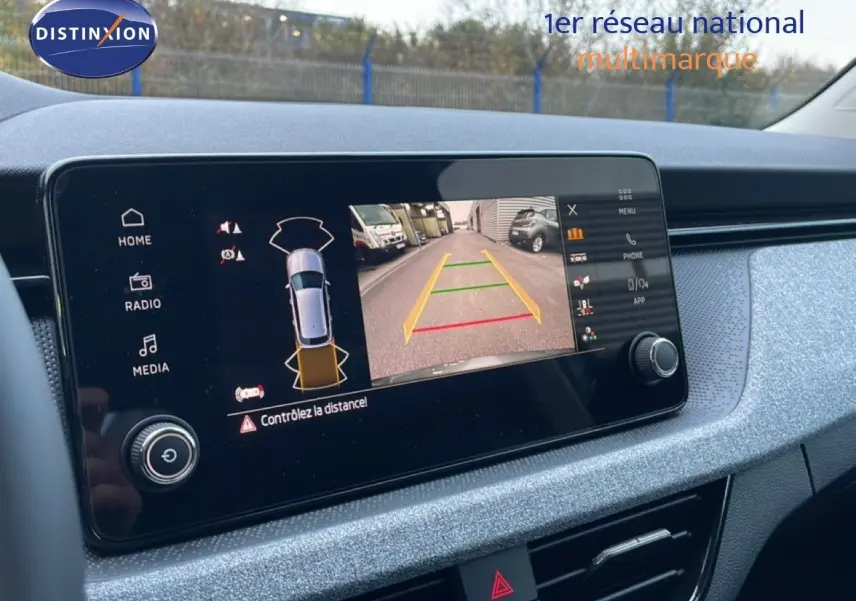 Écran central affichant la caméra de recul avec vue arrière et alertes, intérieur du Skoda Kamiq gris graphite 2025.