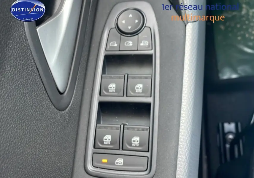 Gros plan sur les commandes des vitres électriques côté conducteur du Dacia Duster 2026, intérieur noir et gris.