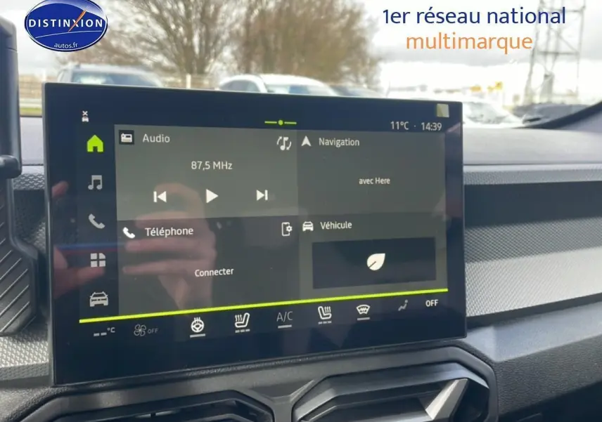 Écran tactile central du tableau de bord du Dacia Duster 2026 avec commandes audio et navigation visibles.