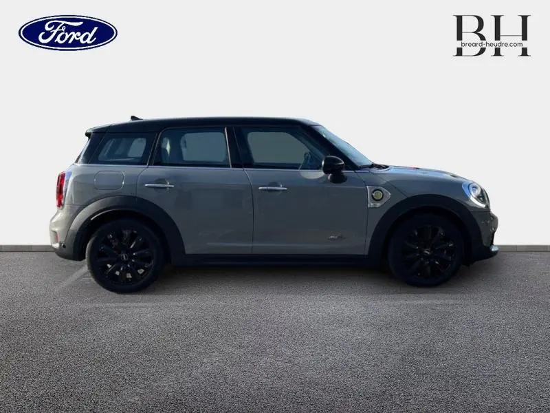 Vue de profil côté gauche d'une MINI Countryman Cooper SE hybride rechargeable en Moonwalk Grey avec jantes noires.