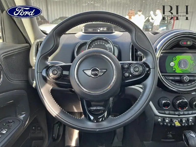 Vue rapprochée du volant cuir noir multifonction d'une MINI Countryman Moonwalk Grey, avec tableau de bord et écran central visible.