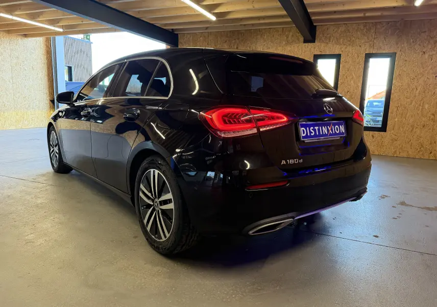 Vue 3/4 arrière d'une Mercedes Classe A noire avec feux LED allumés et sorties d'échappement chromées en intérieur.