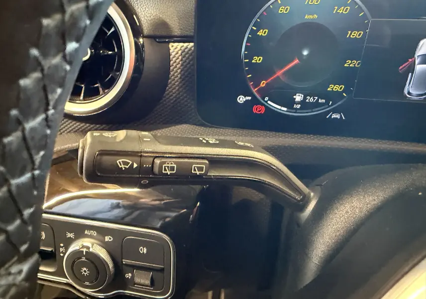 Détail du commodo d’essuie-glace côté gauche avec tableau de bord numérique d’une Mercedes Classe A noire.