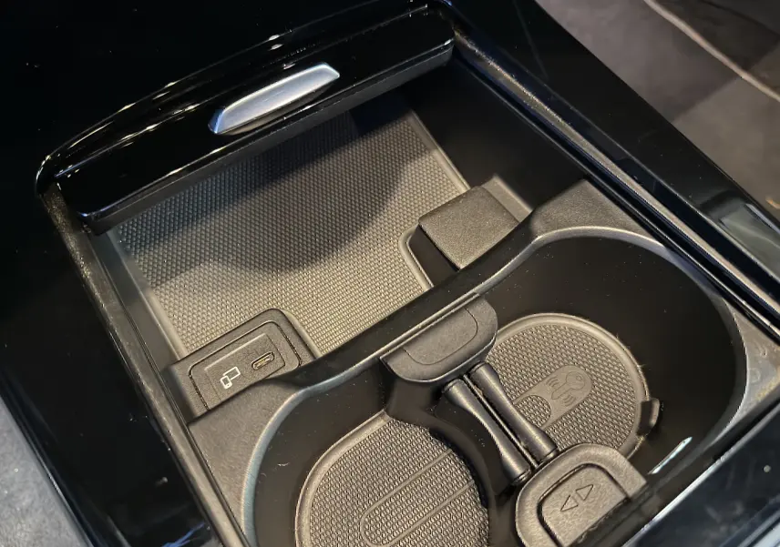 Gros plan sur la console centrale noire avec porte-gobelets et prise USB dans une Mercedes Classe A 2022.