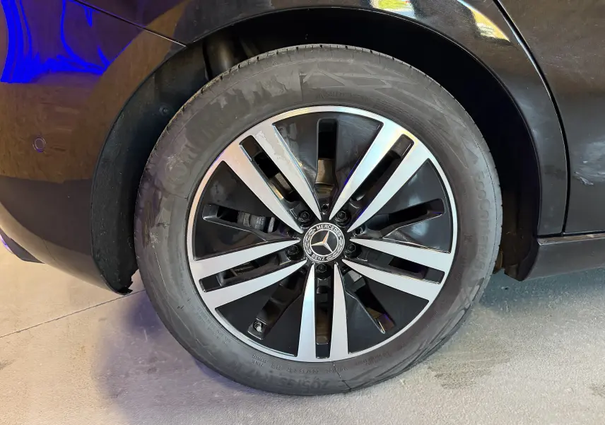 Gros plan sur la jante alu noire et argentée d'une Mercedes Classe A noire, côté arrière droit.