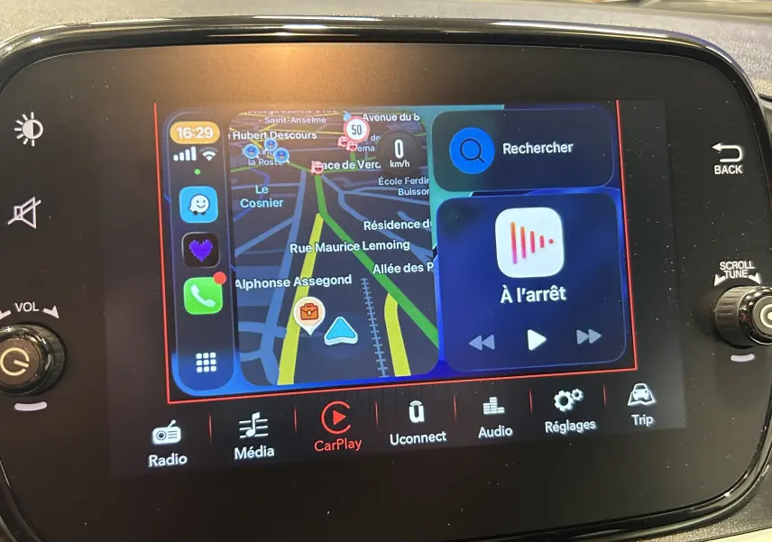 Écran tactile central de la FIAT 500 2023 affichant la navigation CarPlay avec carte et commandes multimédia.