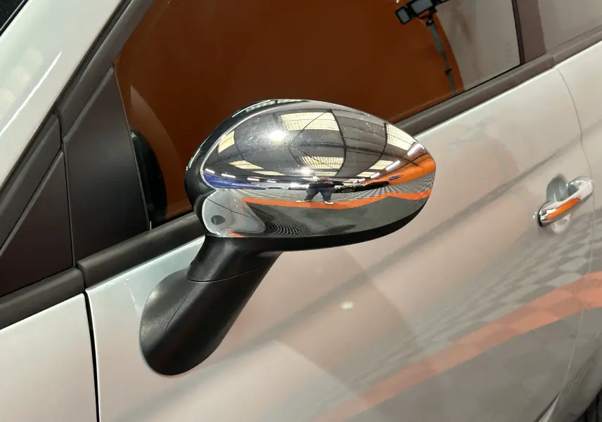 Rétroviseur chromé côté gauche d'une FIAT 500 2023 Rugiada Green, avec poignée de porte assortie visible.