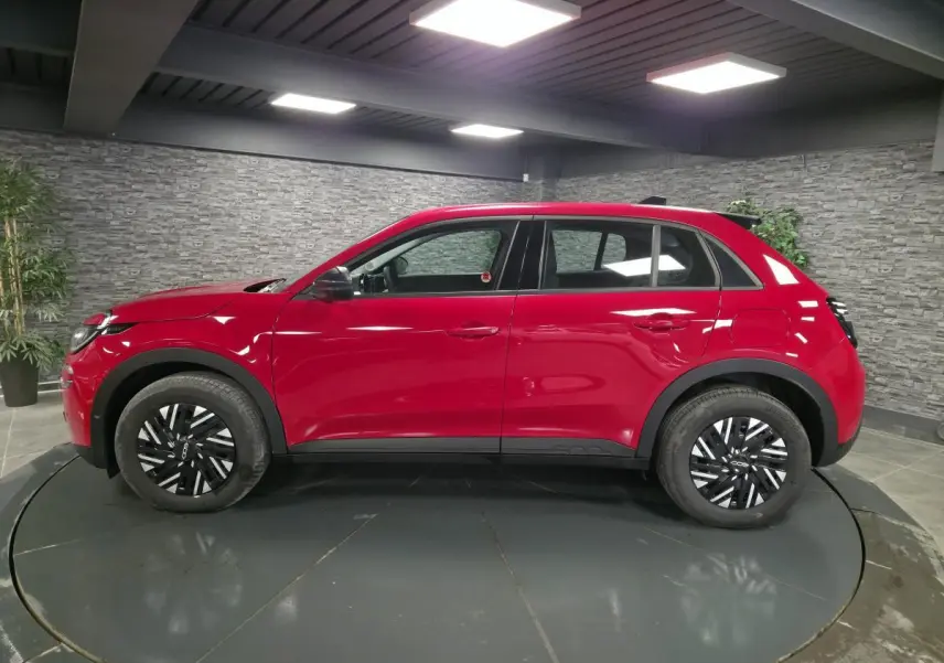 Vue de profil côté gauche du FIAT 600 1.2 Hybrid rouge avec jantes acier bicolores et coques de rétroviseurs noires.