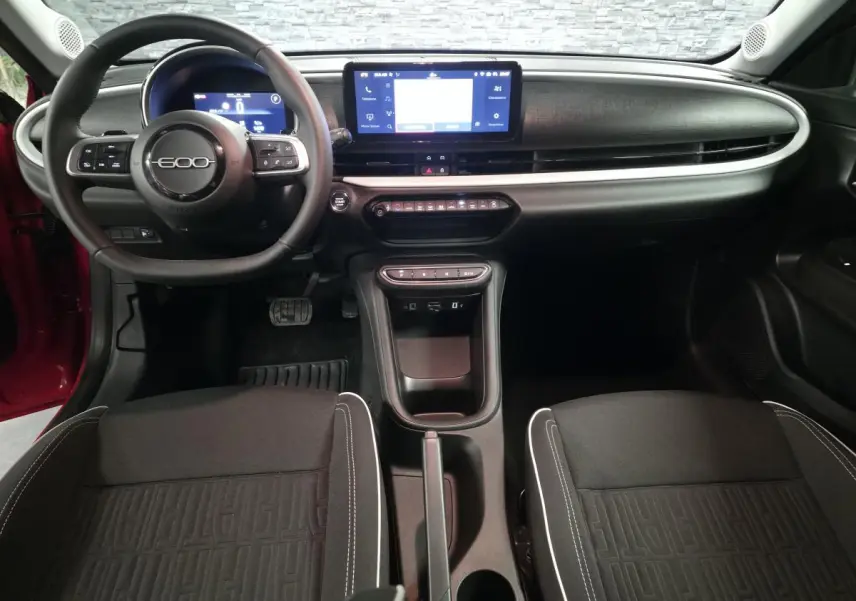 Vue intérieure avant du tableau de bord et volant noir de la FIAT 600 Hybrid 2024 avec écran tactile central.