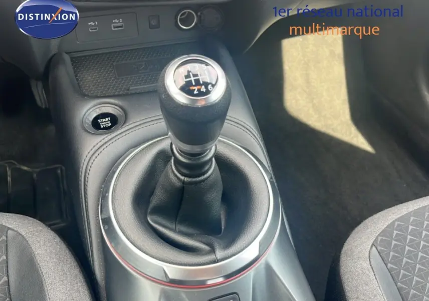 Le levier de vitesses manuel du Nissan Juke rouge Fuji Metal 2024 vu en gros plan dans l'habitacle.