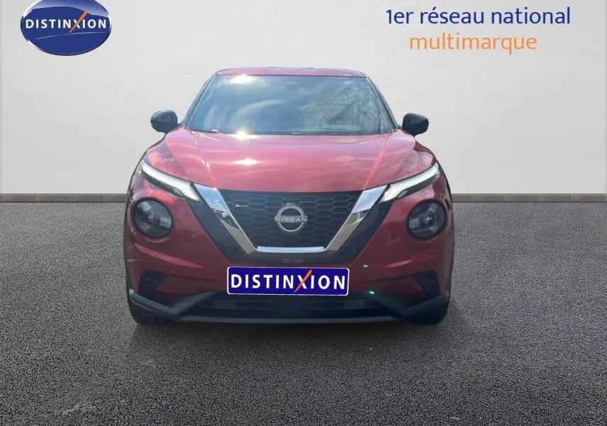 Vue frontale du Nissan Juke 2024 en rouge Fuji Metal avec calandre chromée et phares LED distinctifs.