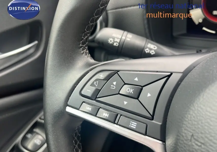 Gros plan sur les commandes au volant côté gauche du Nissan Juke 2024, intérieur noir avec boutons multifonctions.