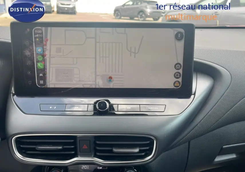 Vue rapprochée de l’écran tactile central et de la console du Nissan Juke rouge Fuji Metal 2024, mettant en valeur l’interface de navigation.