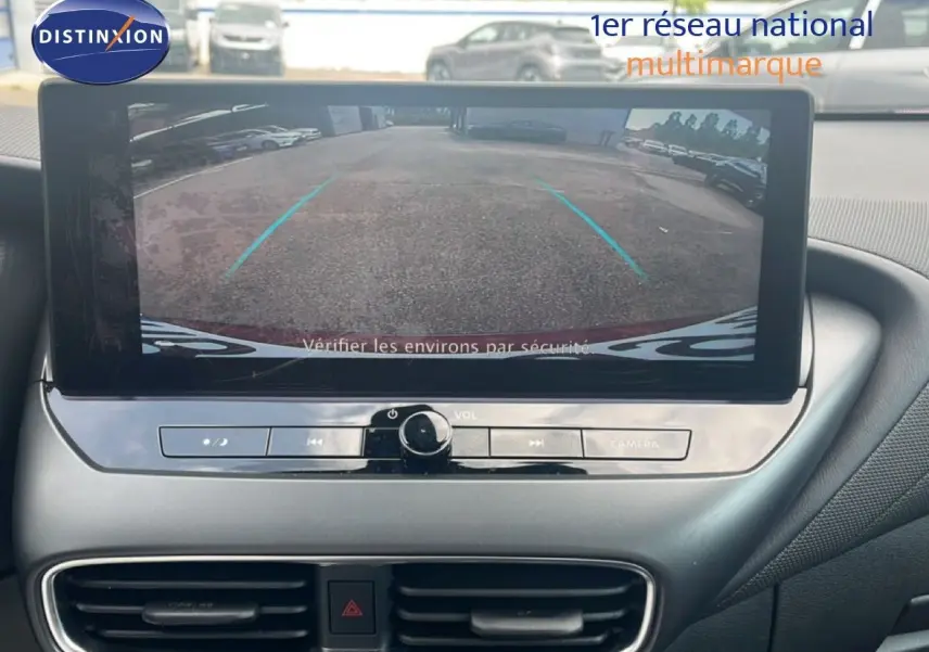 Écran central montrant l’image de la caméra de recul du Nissan Juke rouge Fuji Metal, vue de l’intérieur avant.