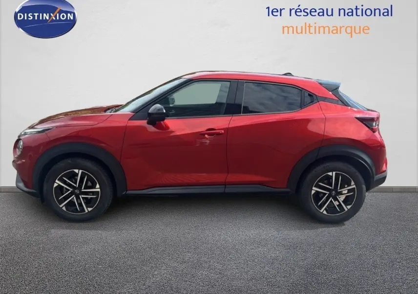 Profil droit d'un Nissan Juke 2024 rouge Fuji Metal avec jantes alliage noires et toit noir contrasté.