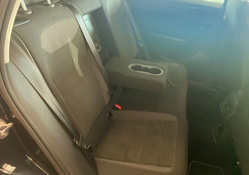 Vue intérieure arrière du SEAT Ateca noir 2019 avec banquette en tissu et accoudoir central rabattable.