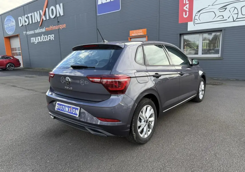 Volkswagen Polo 1.0 TSI gris cendre vue 3/4 arrière droit, avec jantes alliage et feux arrière LED visibles.