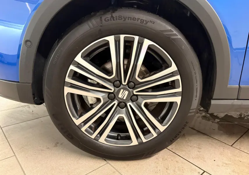 Gros plan sur la roue avant droite du SEAT Arona Bleu Saphir avec jante alliage et partie de la carrosserie visible.