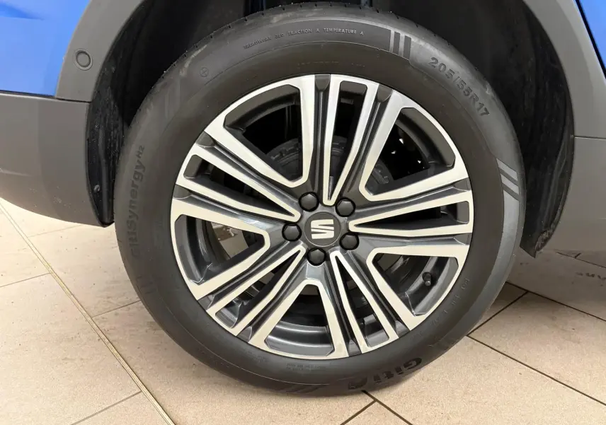 Gros plan sur la jante alliage du côté avant droit d’un SEAT Arona bleu saphir avec toit noir minuit.