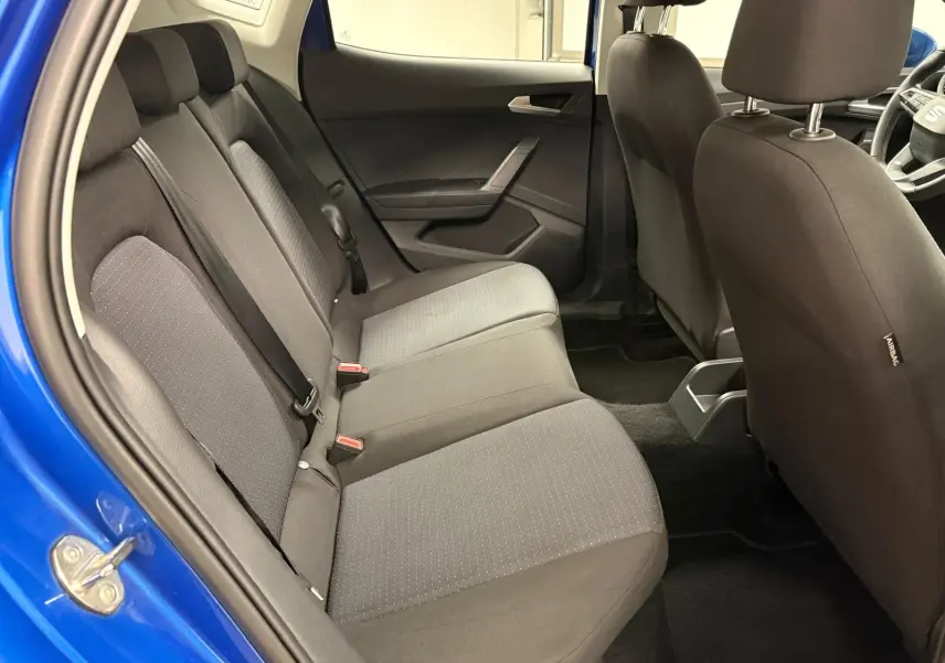 Vue intérieure côté gauche des sièges arrière gris d’un SEAT Arona 2025 bleu saphir avec porte ouverte.
