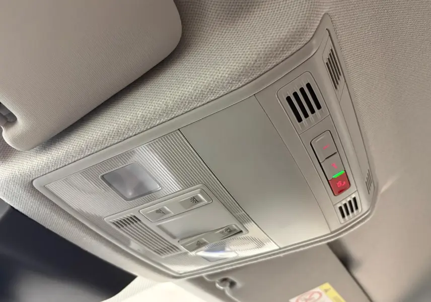 Plafonnier intérieur gris clair du SEAT Arona 2025 avec commandes d’éclairage et ventilation, vue en léger contre-plongée.