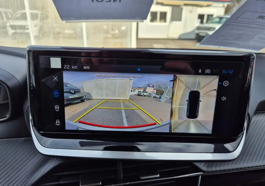 Écran tactile du cockpit numérique de la Peugeot 208 Hybrid blanc, affichant la caméra de recul et vue 360° intérieure.