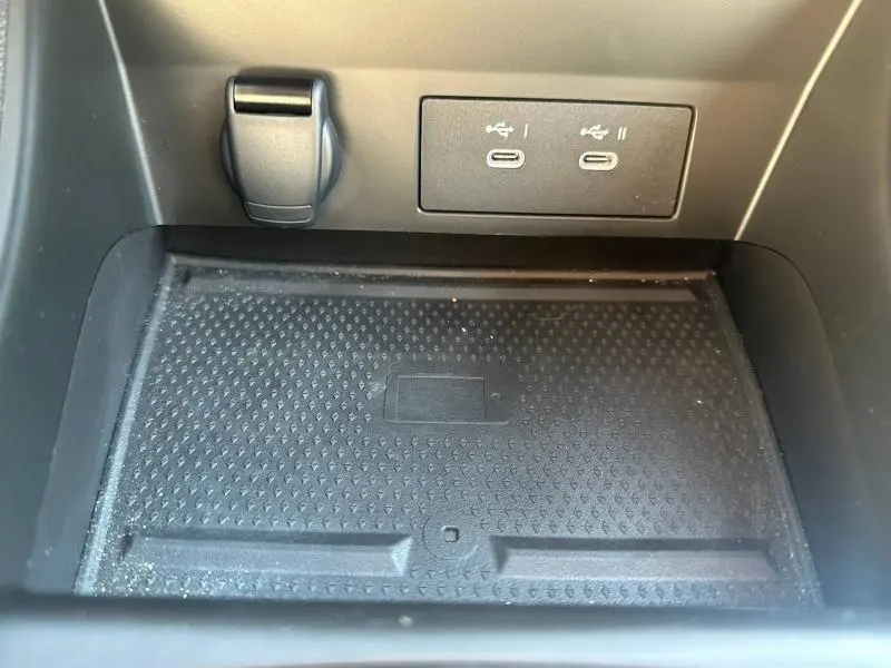 Gros plan intérieur sur le compartiment de recharge sans fil avec deux ports USB-C du Renault Captur 2025.