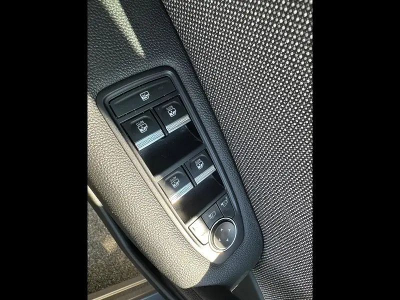 Vue rapprochée des commandes des vitres et rétroviseurs sur la porte côté gauche du Renault Captur gris métallisé.