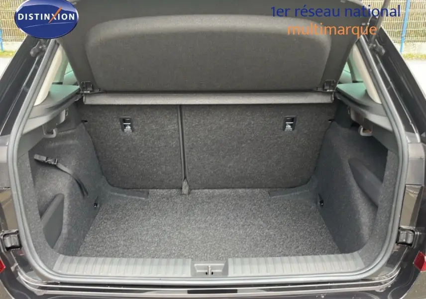 Coffre ouvert vu de l'arrière d'un Skoda Kamiq noir magique métal, montrant un espace de chargement propre et spacieux.