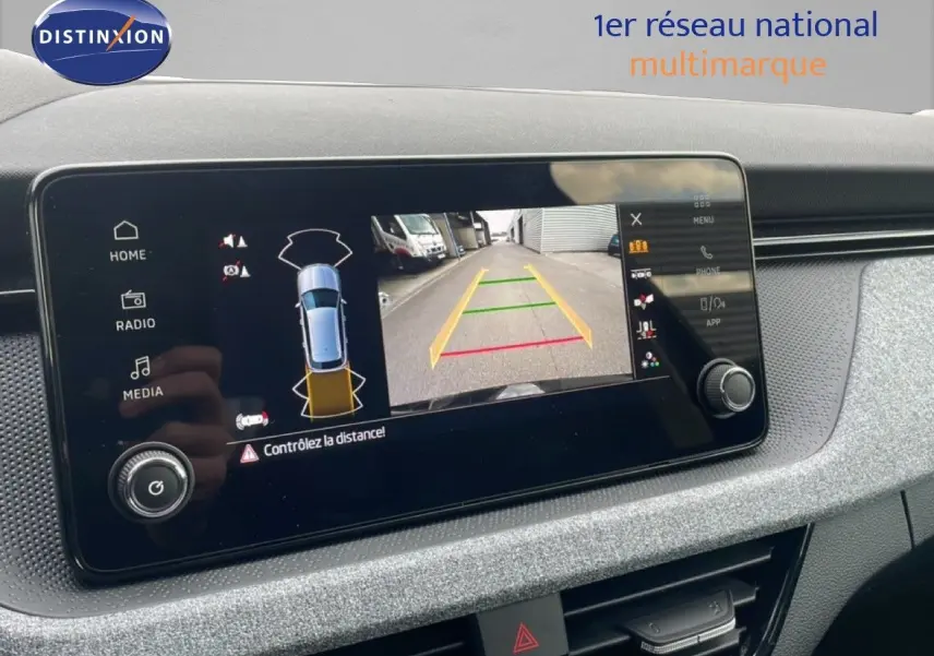 Écran tactile intérieur du Skoda Kamiq 2025 montrant la caméra de recul et l'alerte de distance en mode stationnement.