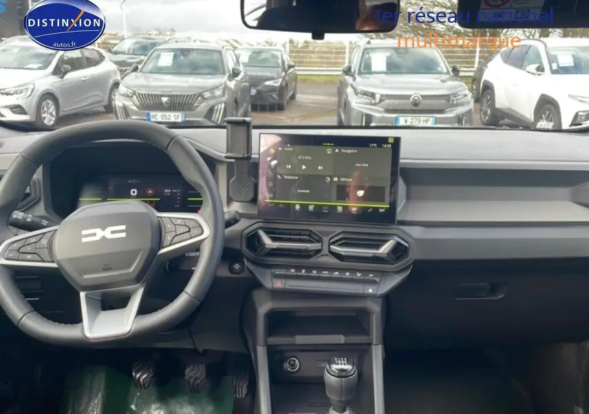 Vue intérieure du tableau de bord et volant du Dacia Duster 1.2 mild hybrid 140 Journey avec écran tactile et boîte manuelle.
