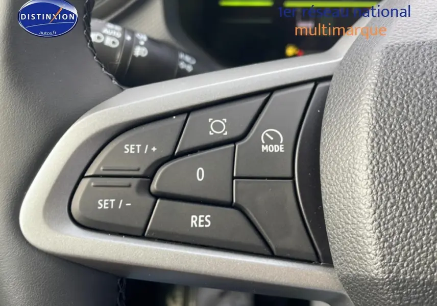 Gros plan sur les commandes multifonctions au volant du Dacia Duster 2026, boutons noirs sur fond gris.
