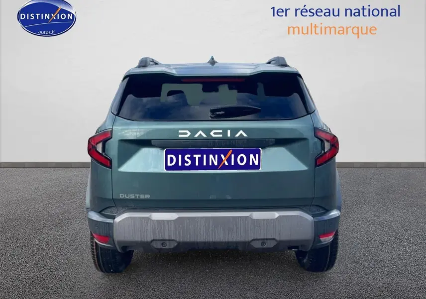 Vue arrière d'un Dacia Duster 2026 vert cèdre avec barres de toit et lunette arrière surteintée.