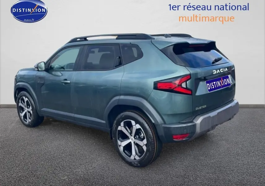 Vue 3/4 arrière droite du Dacia Duster 2026 vert cèdre avec barres de toit et jantes alu distinctives.
