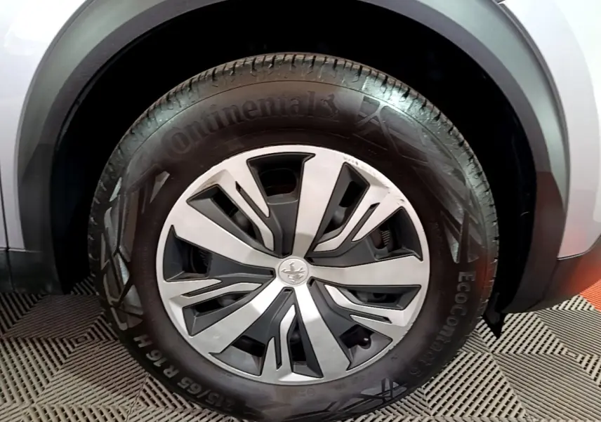 Gros plan sur la roue avant droite d’un Peugeot 2008 gris clair, avec jante alliage et pneu Continental.
